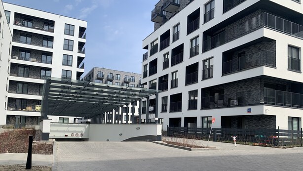 Een modern appartementencomplex met meerdere balkons en een overdekt terras.