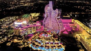 A hotel with a guitar-shaped building, multiple swimming pools, and a well-lit resort area. - Beach Front Spacious 1BR , The Tides, Hollywood,FL (Hollywood)