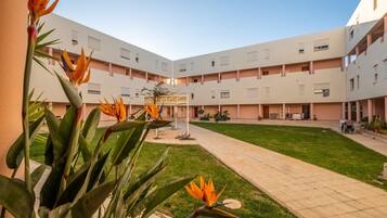 A courtyard with a central lawn, surrounded by multi-story buildings with balconies and windows.