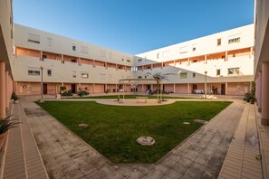 Ein Innenhof mit einer zentralen, runden Fläche, umgeben von mehrstöckigen Gebäuden mit Balkonen.