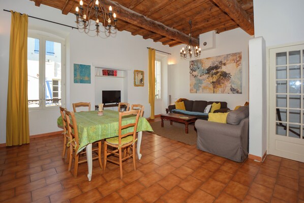 A dining area with a table and chairs, a sofa, and a painting on the wall. - Townhouse near historical center of Tarascon (Tarascon)