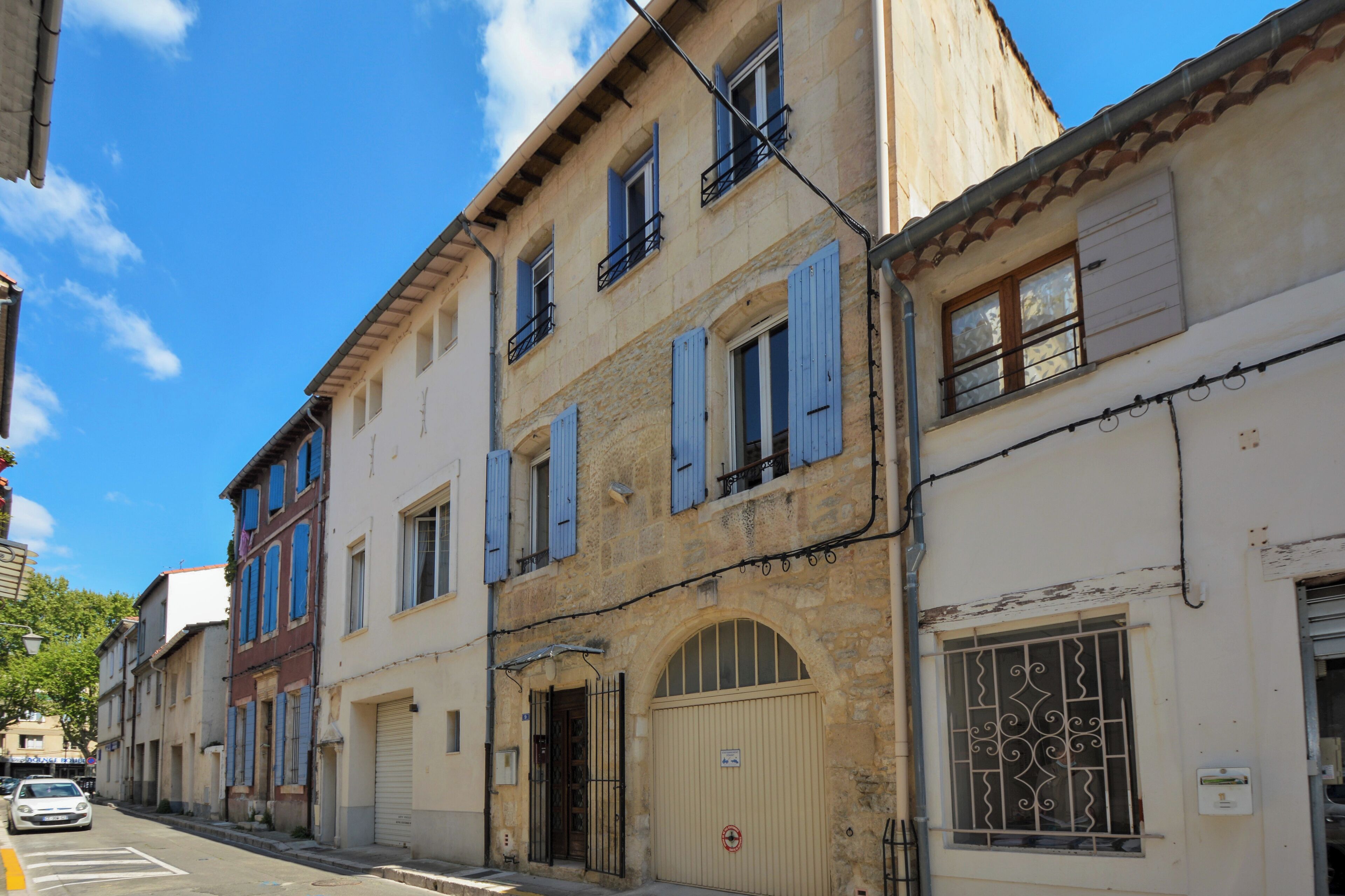 Une rangée de bâtiments européens traditionnels, caractérisés par un style architectural uniforme, avec des portes en arc de cercle et des fenêtres à volets.