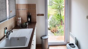 Un bagno con lavandino, WC e doccia. Si vede un giardino dalla finestra.