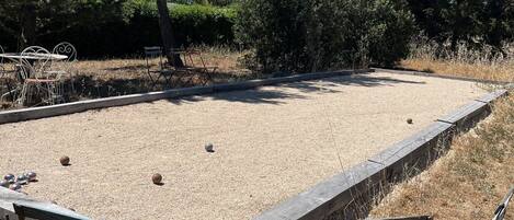 A billiards table with surrounding seating and a gravel area.