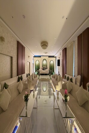 A spacious, well-lit room with a central seating area, a glass coffee table, and a decorative vase. - Holiday Al Khaleej Hotel (Al Khobar)