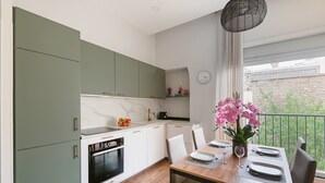 A modern kitchen with green cabinets, a marble countertop, and a dining area with a wooden table and chairs. - 4bed/4bath, Luxury AND Calm, 10min Walk From Beach (Cannes)