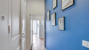 A hallway with a blue wall and framed pictures. - 4bed/4bath, Luxury AND Calm, 10min Walk From Beach (Cannes)