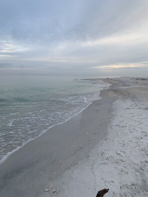 A beach with a sandy shore and calm waves.