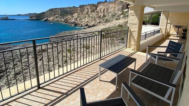 Un balcó amb vista al mar i penya-segats rocosos.