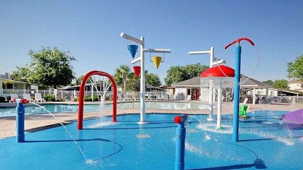Un espace de jeux aquatiques doté de plusieurs jets d’eau et d’entonnoirs colorés.