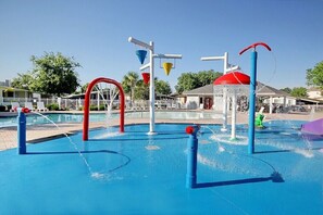 Un espace de jeux aquatiques doté de plusieurs jets d’eau et d’entonnoirs colorés.