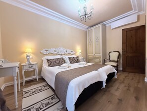 Una camera da letto con un letto, comodini, una sedia, un armadio e un lampadario.