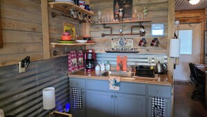 Une cuisine rustique avec des murs en bois, un coin café et divers ustensiles de cuisine.