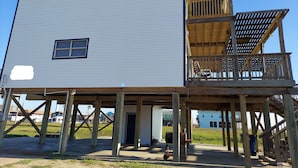 A two-story wooden structure with a balcony on the upper level. - Amazing 5-bedroom beachfront home waiting for your getaway, sleeps 16 (Surfside Beach)