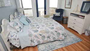 A bedroom with a bed, a chair, a dresser, and a window with a view. - Amazing 5-bedroom beachfront home waiting for your getaway, sleeps 16 (Surfside Beach)