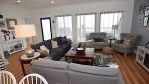 A living room with a grey sofa, patterned armchairs, a coffee table, and a white side table. - Amazing 5-bedroom beachfront home waiting for your getaway, sleeps 16 (Surfside Beach)