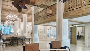 Un vestíbulo amplio con techos altos, candelabros y una escalera.