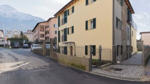 A multi-story building with a stone facade and a gated entrance. - Ciclamino Apartment Residenze Lariane (Colico Piano)