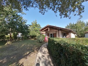 A single-story wooden house with a sloped roof, a front porch, and a number '42' sign.