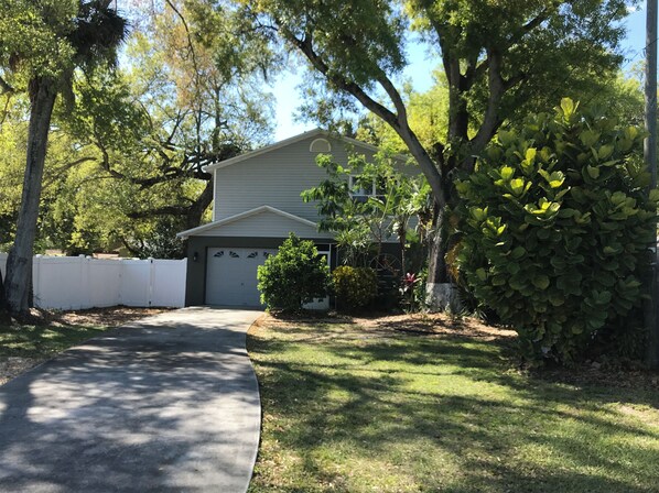 Simple, single-story home surrounded by a well-maintained lawn and trees.