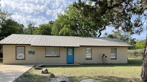 A single-story building with a blue door, a small porch, and a sign reading "Casa Amigós." - Casa Amigos (Concan)