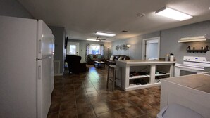 A kitchen with a refrigerator, stove, and bar stools. - Casa Amigos (Concan)