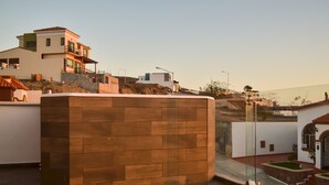 A modern building with a flat roof, a balcony, and a view of the surrounding area. - Jacuzzi Pool Spa Ocean View 4bd 5ba House (El Sauzal)