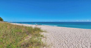 A beach with a clear sky and calm sea.