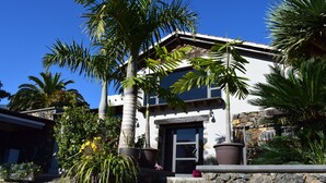 A two-story house with a stone facade, large windows, and a front porch with potted plants. - Finca La Masía - Relax - Vistas - Internet (La Orotava)