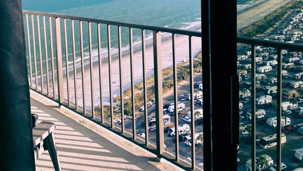 Un balcon avec vue sur la plage et l’océan.