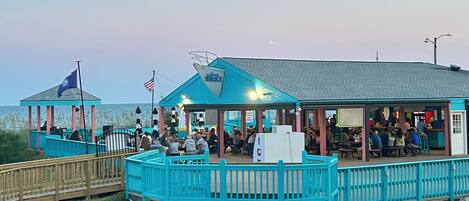 A waterfront restaurant with outdoor seating and a covered area.