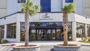 La Renaissance Tower se distingue par sa façade moderne, ses grandes fenêtres et les palmiers qui l’ornent.