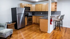 Una cocina moderna con armarios de madera, electrodomésticos de acero inoxidable y encimera de granito.