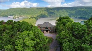 Un chalet entouré d’une forêt dense et situé au bord d’un lac, offrant une vue dégagée sur le paysage environnant.