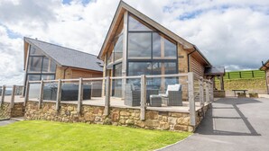 A modern building with large windows and a stone foundation. - Valley View Lodge Sleeps 8 With Hot Tub (Preston)