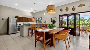 A modern kitchen with a central island, wooden chairs, and a dining table. - Los Gallos - Second Level Apartment (Lo de Marcos)