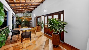 An indoor patio with a wooden ceiling, tiled floor, and potted plants. - Los Gallos - Second Level Apartment (Lo de Marcos)
