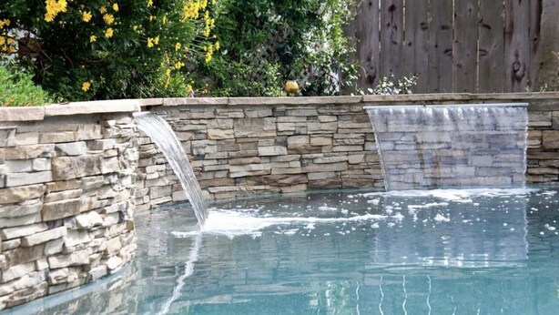 A stone-lined pool with a waterfall feature. - Large Family home near Sequoia National Park (Visalia)
