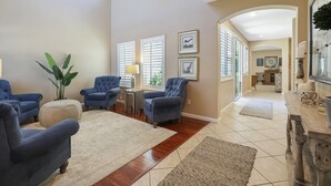 A spacious living room with blue armchairs, a beige rug, and a wooden coffee table. - Large Family home near Sequoia National Park (Visalia)