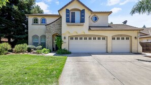 A two-story house with a garage, stone facade, and a well-maintained lawn. - Large Family home near Sequoia National Park (Visalia)