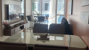Une cuisine moderne avec un coin repas, un ventilateur de plafond et une vue sur l’extérieur.