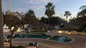 Un área de piscina con diversas opciones de asientos y palmeras.