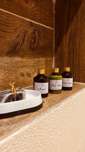 Three bottles of body wash on a wooden shelf. - Beautiful 2-Bed Apartment at PamV Estates Apt7 (Accra)