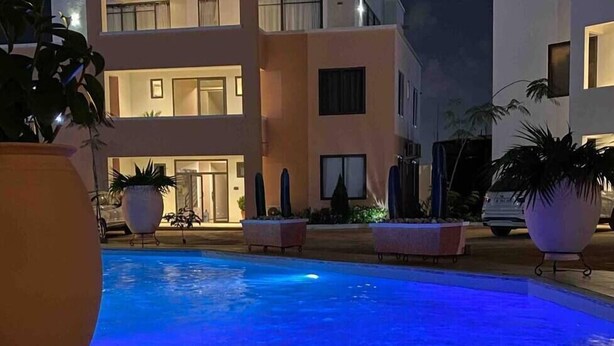 Un bâtiment moderne avec une piscine, de nuit.