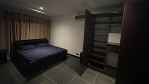 A bedroom with a bed, a wardrobe, and a desk. - Remarkable 2-Bed Apartment in Accra (Accra)