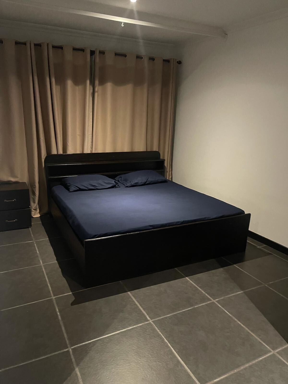 Ein Schlafzimmer mit einem Einzelbett, einem Nachttisch und einem Kleiderschrank.