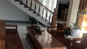 Un amplio salón con una escalera de madera, un largo banco de madera y una mesa de centro.