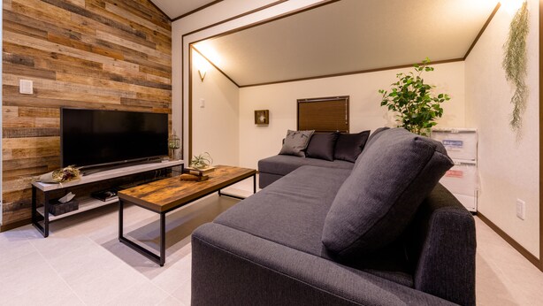A modern living room with a flat-screen TV, a wooden accent wall, a gray sofa, and a wooden coffee table. - Dio (Fujikawaguchiko)