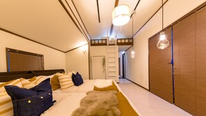 A bedroom with a bed, pillows, a fur rug, a ladder, and a window with blinds. - Dio (Fujikawaguchiko)