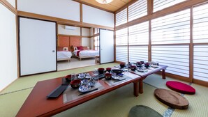 A traditional Japanese room with tatami flooring, a low wooden table set with dishes, and sliding doors leading to a bedroom. - RAKUWA Bettei (Fujikawaguchiko)